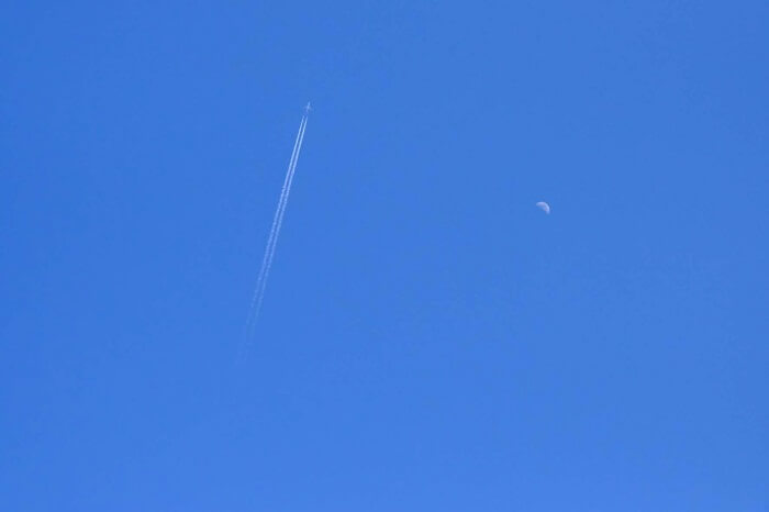 飛行機雲と昼中の月